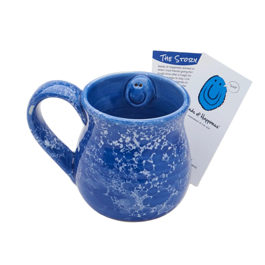 Blue speckled mug with a smiling face on a white background